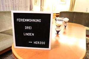 a sign on top of a wooden table at Drei Linden Herzog in Wolfenbüttel