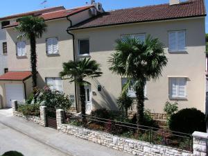 a house with palm trees in front of it at Apartments Nicole in Pula