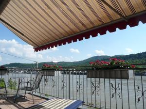 a balcony with chairs and a view of the water at Hotel Garni Rheinpracht in Kamp-Bornhofen