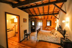 a bedroom with a bed and a wooden ceiling at Quinta da Rabaçosa - Turismo Rural in Castro Daire