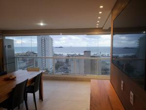 duży pokój ze stołem i dużym oknem w obiekcie Apto com Vista para o Mar e ampla Varanda Gourmet w mieście Guarujá