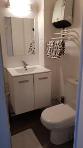 een badkamer met een wit toilet en een wastafel bij " LA BIENVENUE " in Ploemeur