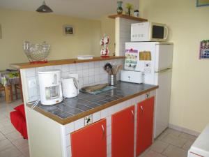 una cocina con electrodomésticos rojos y blancos en la encimera en Logement Soulac sur mer, en Soulac-sur-Mer