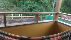 a hammock on the balcony of a house at Camburi suites in Camburi