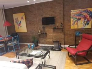 sala de estar con pared de ladrillo y TV en Fully Furnished Entire Floor Apartment in Historic Harlem, en Nueva York