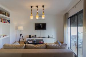 a living room with a couch and a table at Condomínio Ondas do Mar -Coastal Comfort- in Olhão