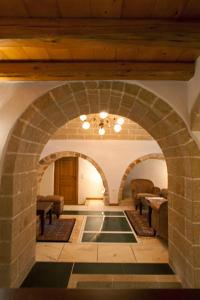 an archway in a building with chairs and tables at Likinia Hotel in Monemvasia