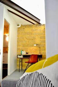 - une chambre avec un lit et un bureau avec une chaise dans l'établissement Joli studio avec terrasse-jardin sur les toits, coeur historique, à Montpellier