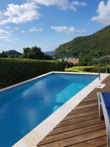 a blue swimming pool with a wooden deck at Casa Vista in Marigot Bay