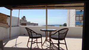 una mesa y sillas en un balcón con vistas en Grande Apto. equipado no Porto Barra, en Salvador