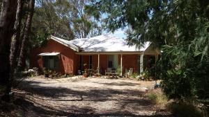 a brick house in the middle of a forest at Stringybark Hills Retreat in Mylor