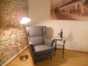 una lámpara sentada junto a una silla junto a una pared en Suite CALLIOPE - LE MUSE en Pietrasanta