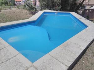 ein Swimmingpool mit blauem Wasser in einem Hof in der Unterkunft Casa en Playa Perelli in Villa Carlos Paz + 23 Fotos