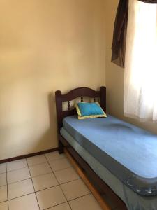 a small bedroom with a bed and a window at Casa para temporada in Governador Celso Ramos