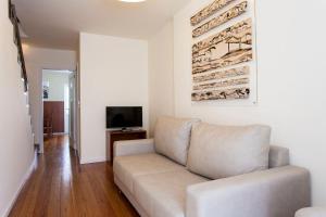 ein Wohnzimmer mit Sofa und Fernseher in der Unterkunft Exquisit Flat Left in Lissabon