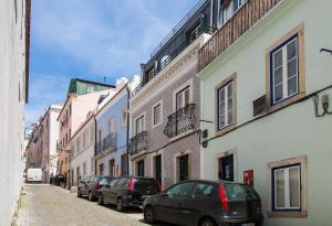 eine Reihe von Autos, die auf einer Straße mit Gebäuden geparkt sind in der Unterkunft Exquisit Flat Left in Lissabon