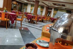 une salle à manger avec des tables, des chaises et des tables violettes dans l'établissement Sapta Nawa Resort 1 Gresik, à Gresik