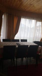 a dining room with a table and chairs and curtains at Cabaña Dalcahue Avenida Mocopulli in Dalcahue