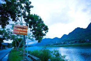 un panneau indiquant un hôtel à côté d'une rivière dans l'établissement Phong Nha Friendly Home, à Phong Nha