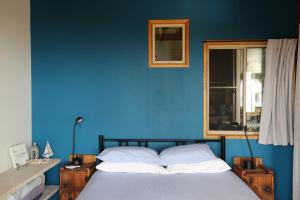 niebieska sypialnia z łóżkiem i oknem w obiekcie Benji's By The Sea w mieście Scotts Head