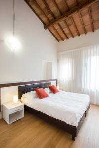 una camera da letto con un grande letto con due cuscini rossi di San Lorenzo Apartments a Colle Val D'Elsa