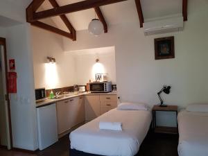 uma pequena cozinha com duas camas num quarto em Byron Bay Rainforest Resort em Byron Bay