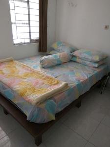 1 dormitorio con cama con edredón y almohadas en Homestay Pesona en Garut