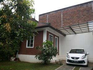 un coche blanco estacionado frente a una casa en Homestay Pesona en Garut