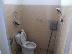 een kleine badkamer met een toilet en een douche bij Homestay Pesona in Garut