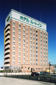 een groot gebouw met een bord erop bij Hotel Route-Inn Shibata Inter in Shibata