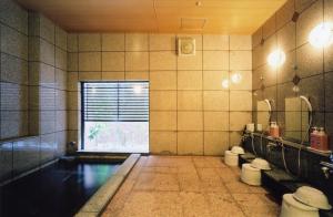 a bathroom with a tub and a window with a mirror at Hotel Route-Inn Shibata Inter in Shibata