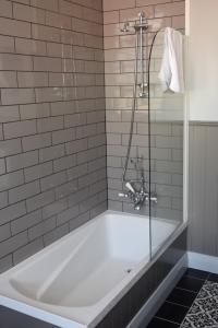 a bath tub with a glass shower in a bathroom at Left Bank in Kaikohe