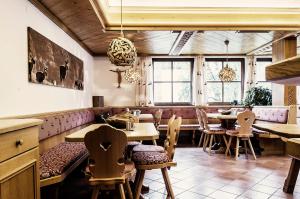 a restaurant with tables and chairs and windows at Atelier Garni Astei in Grossarl