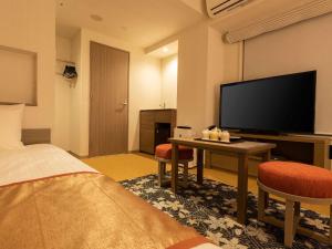 a hotel room with a bed, desk and television at Tokyu Stay Kyoto Sanjo-Karasuma in Kyoto