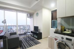 een keuken met een woonkamer en een wasmachine bij Apartemen Menteng Park by Aparian in Jakarta