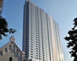 een hoog gebouw met een kerk ervoor bij Apartemen Menteng Park by Aparian in Jakarta