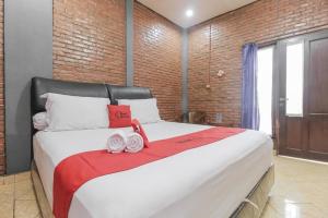 - une chambre avec un grand lit et une couverture rouge dans l'établissement RedDoorz Plus At Ampera Raya, à Jakarta