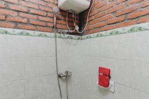 a shower in a bathroom with a brick wall at RedDoorz Plus At Ampera Raya in Jakarta