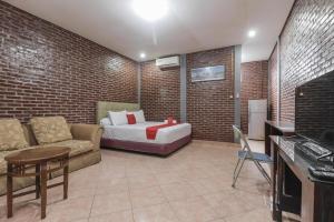 una camera con letto e divano di RedDoorz Plus At Ampera Raya a Giacarta