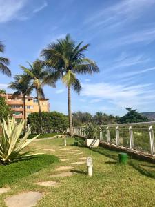 a park with two palm trees and a fence at TOTAL Mar in Niterói