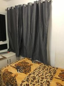 a bedroom with a leopard print bed with a curtain at TOTAL Mar in Niterói