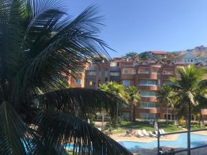 uma vista para um resort com uma piscina e palmeiras em TOTAL Mar em Niterói