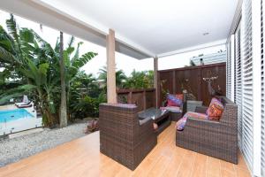 een patio met 2 stoelen en een zwembad bij Kia Orana Villas and Spa in Rarotonga