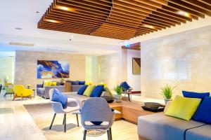 a living room with blue and yellow furniture at Shama Sukhumvit Bangkok in Bangkok