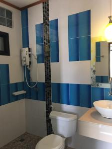 La salle de bains bleue et blanche est pourvue de toilettes et d'un lavabo. dans l'établissement Baan Mulan, à Ko Samet
