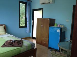 Baan Mulan في كو ساميد: غرفة نوم بسرير وطاولة وجدار ازرق