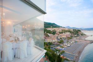 a white dining room with a view of the ocean at Hotel Voce del Mare in Vietri sul Mare