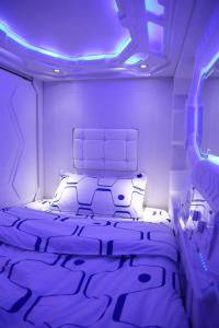 Bett in einem Zimmer mit violetten Lichtern in der Unterkunft Dormitos in Manila