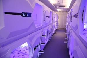 a aisle in an empty room with purple shelves at Dormitos in Manila