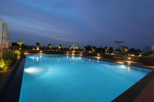 a large swimming pool at night on a building at Monsoon Empress Kochi in Cochin